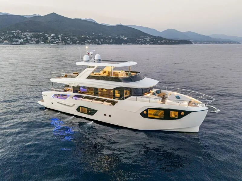Slide: The Image of 2025 Absolute 70 Navetta yacht cruising on serene waters at sunset. - 34