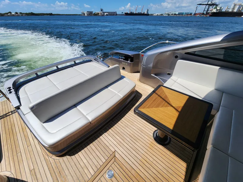 Slide: The Image of 2022 Pershing 6X yacht deck with seating and table, cruising on open water. - 13