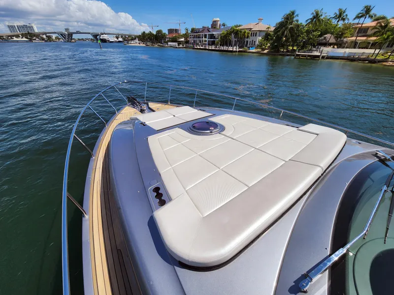 Slide: The Image of 2022 Pershing 6X yacht on a sunny waterway, featuring sleek deck design. - 14