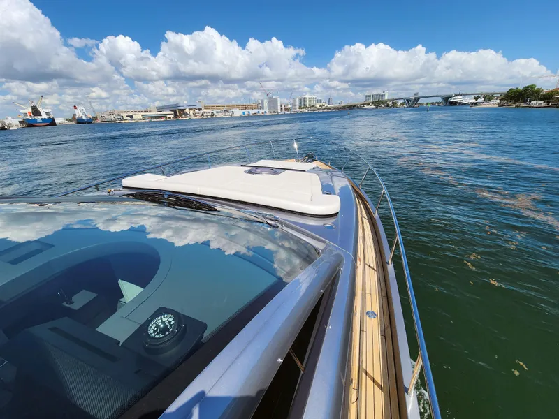 Slide: The Image of 2022 Pershing 6X yacht cruising on a sunny day with cityscape in the background. - 15