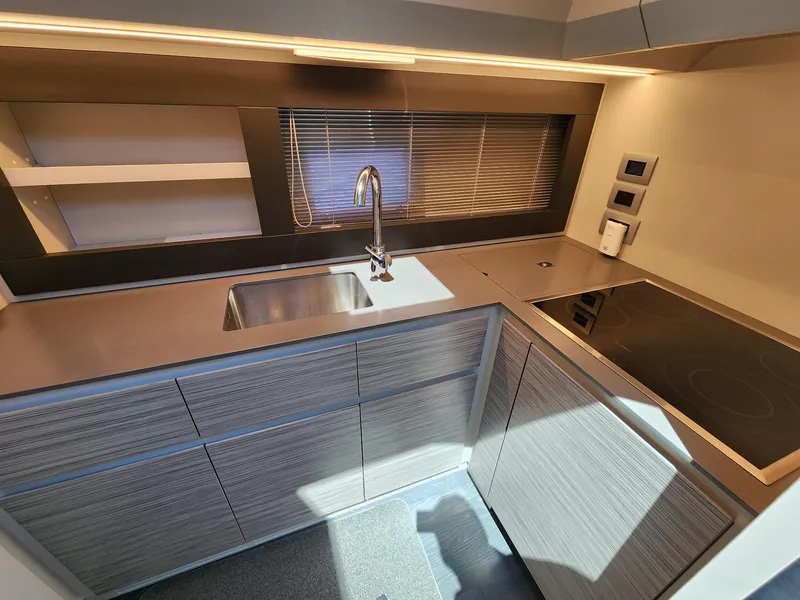 Slide: The Image of Modern kitchen in 2022 Pershing 6X yacht with sleek cabinetry and stainless steel sink. - 21