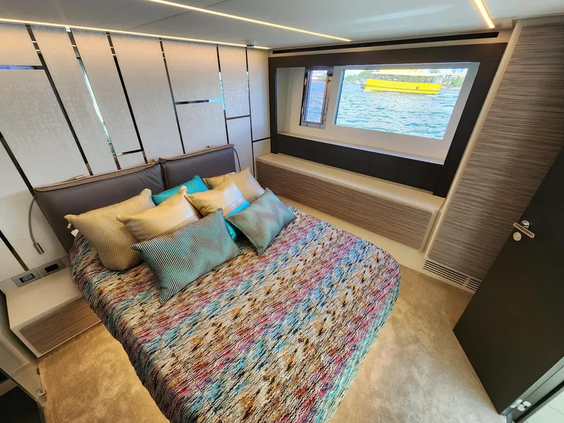 Slide: The Image of Luxurious bedroom interior of 2022 Pershing 6X yacht with colorful bedding and sea view. - 25
