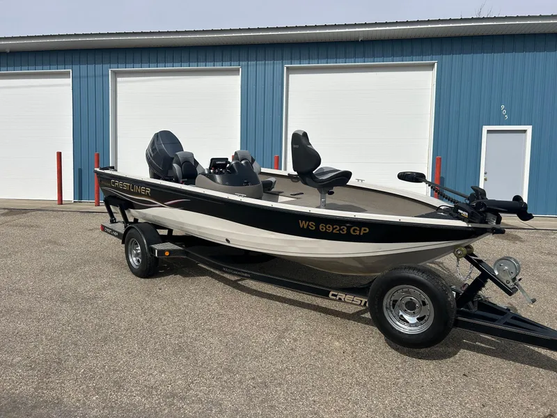 Slide: The Image of 2004 Crestliner 1750 FishHawk SC boat on trailer, parked near blue building. - 0