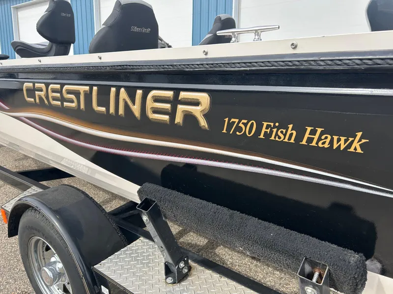 Slide: The Image of 2004 Crestliner 1750 FishHawk SC boat, black exterior, side view with logo. - 19