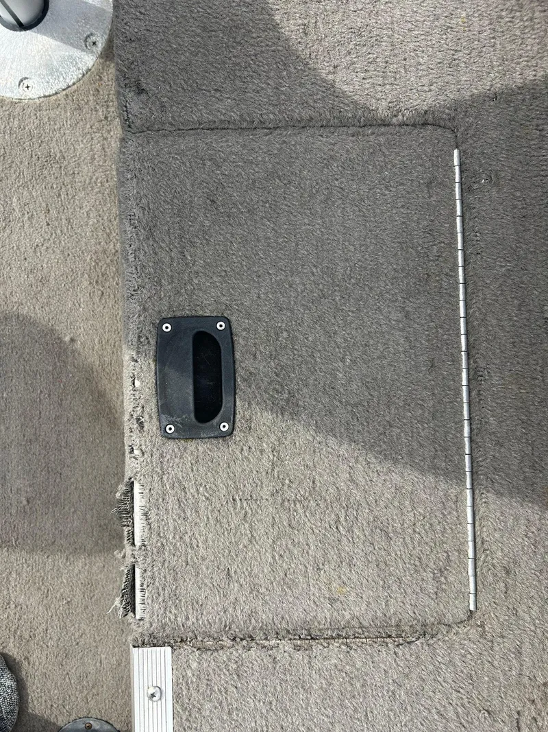 Slide: The Image of 2004 Crestliner 1750 FishHawk SC boat carpeted floor with hatch and handle. - 24