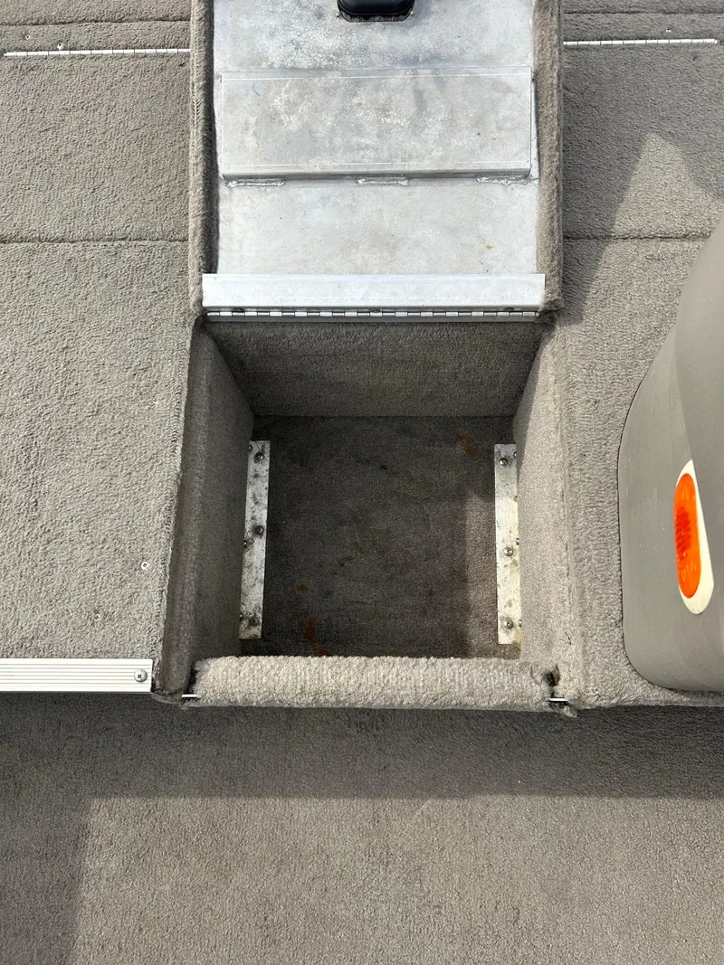 Slide: The Image of 2004 Crestliner 1750 FishHawk SC boat interior storage compartment with gray carpet. - 26