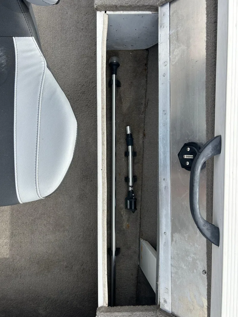 Slide: The Image of Storage compartment in a 2004 Crestliner 1750 FishHawk SC boat, featuring a rod holder. - 28