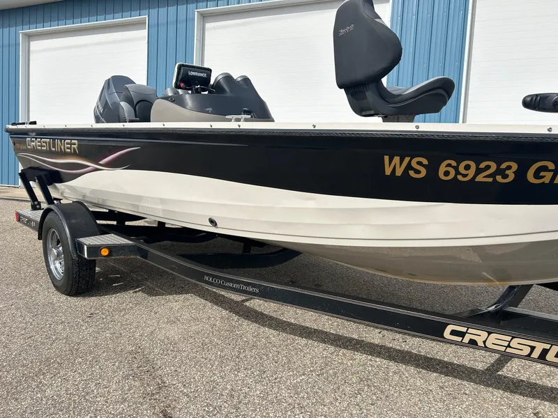 Slide: The Image of 2004 Crestliner 1750 FishHawk SC boat on trailer, parked near blue building. - 4