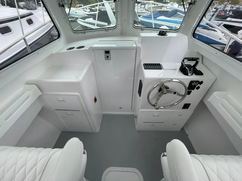 Slide: The Image of Interior of 2025 Steiger Craft 255 DV MIAMI boat, featuring helm and seating area. - 10