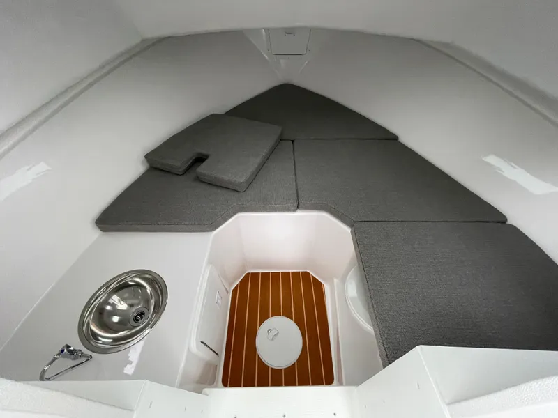Slide: The Image of 2025 Steiger Craft 255 DV MIAMI cabin interior with gray cushions and wooden flooring. - 7