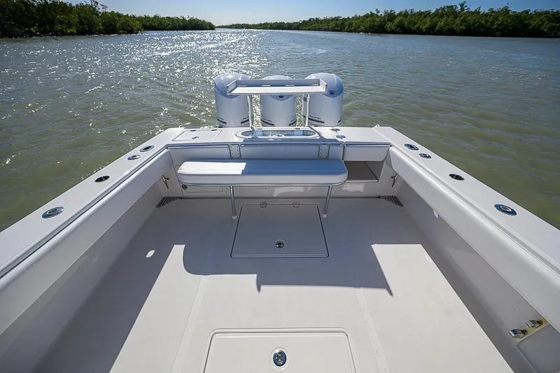 Slide: The Image of 2017 Bahama 41 boat deck with seating, overlooking calm waters and lush shoreline. - 12