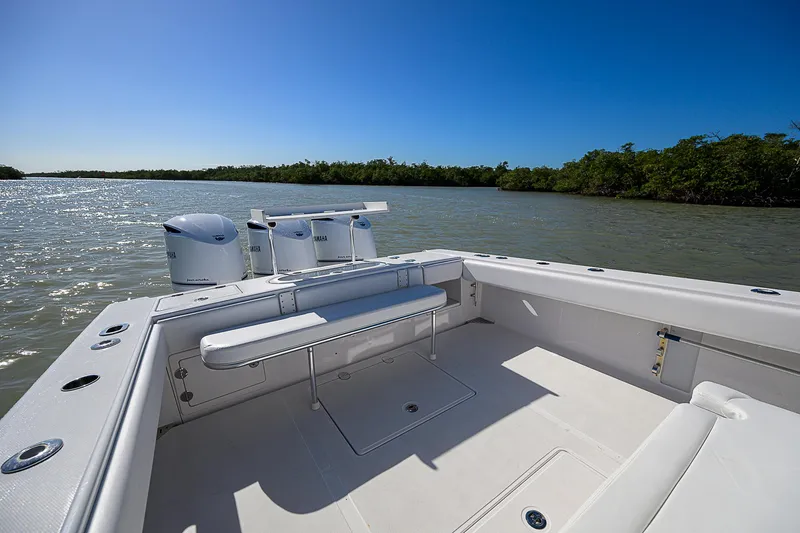 Slide: The Image of 2017 Bahama 41 boat on calm waters, featuring spacious deck and seating. - 14