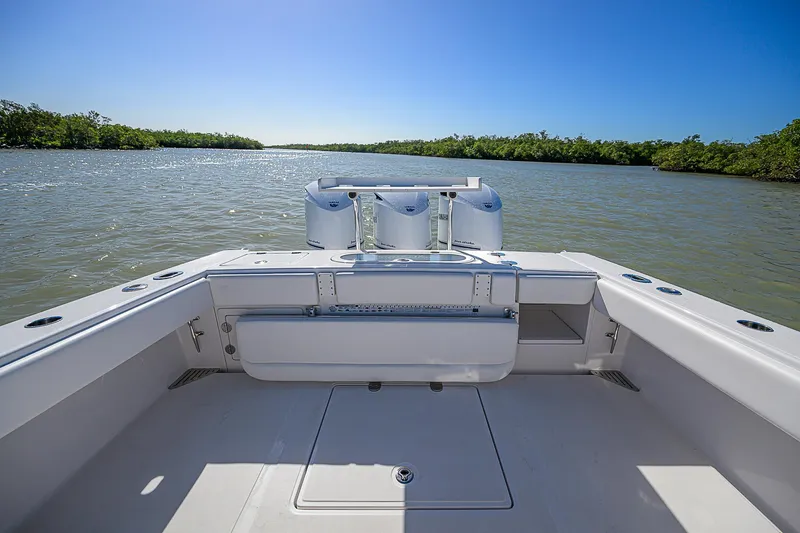 Slide: The Image of 2017 Bahama 41 boat on calm water, featuring spacious deck and clear blue sky. - 15
