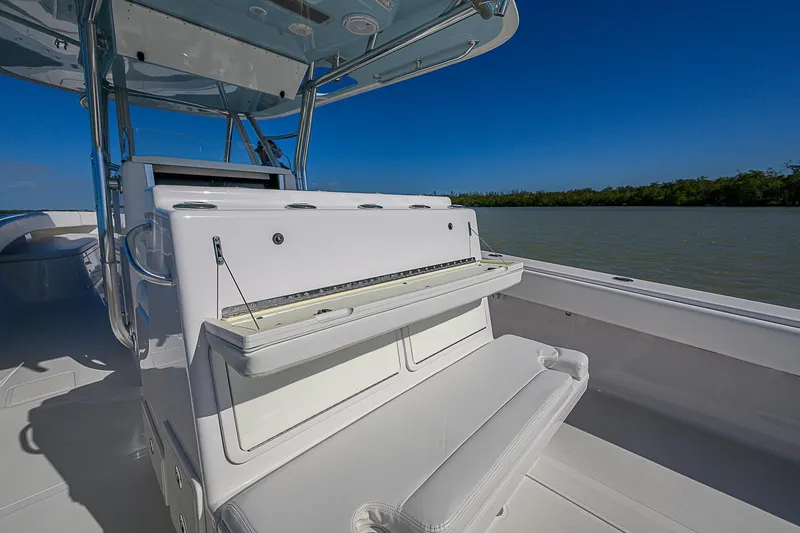 Slide: The Image of 2017 Bahama 41 boat interior with seating, under clear blue sky, near water and greenery. - 21