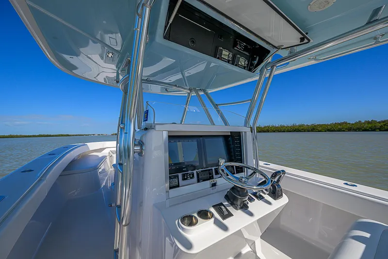 Slide: The Image of 2017 Bahama 41 boat cockpit with steering wheel and navigation equipment on a sunny day. - 27