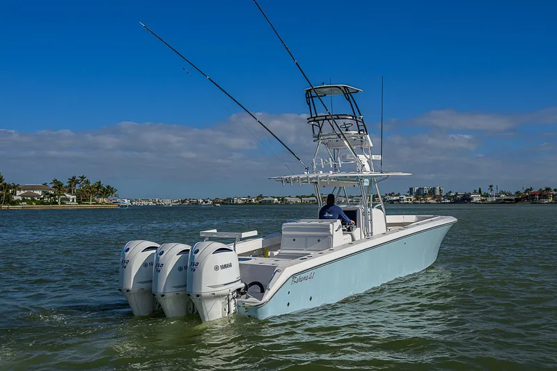 Slide: The Image of 2017 Bahama 41 boat with triple Yamaha engines cruising on a sunny day. - 37