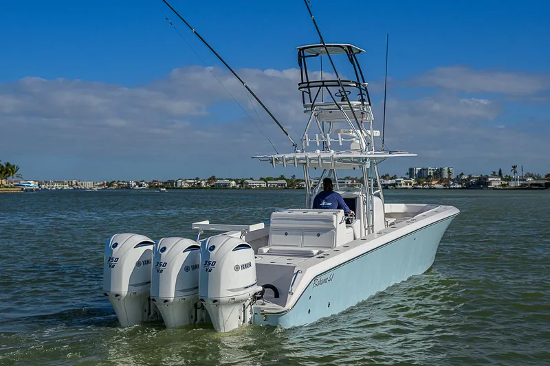 Slide: The Image of 2017 Bahama 41 boat with triple outboard engines cruising on a sunny day. - 38