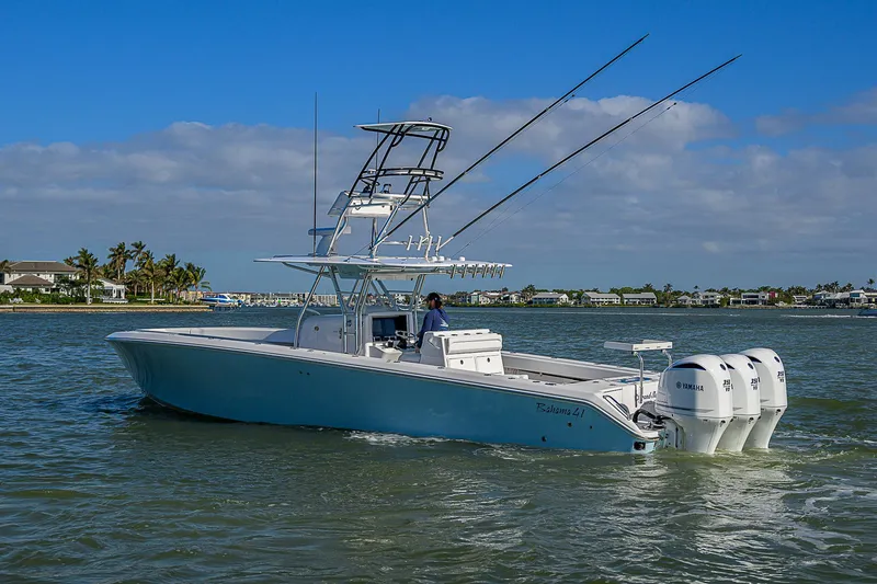 Slide: The Image of 2017 Bahama 41 boat on water with triple outboard engines, clear sky background. - 41
