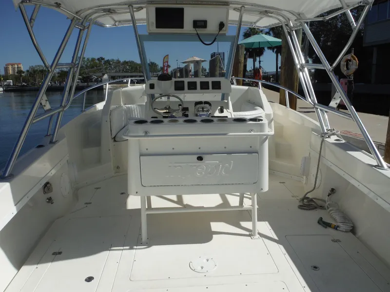 Slide: The Image of 1996 Intrepid 339 Walk Around boat with spacious cockpit and helm, docked at marina. - 23