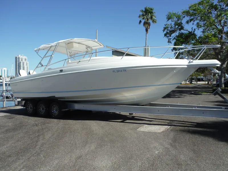 Slide: The Image of 1996 Intrepid 339 Walk Around boat on trailer, parked outdoors with trees in the background. - 3