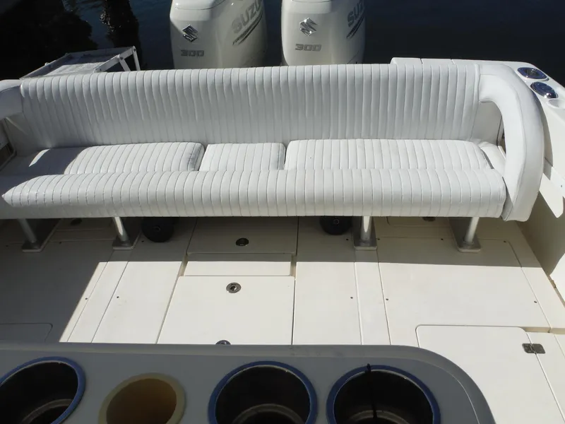 Slide: The Image of 1996 Intrepid 339 Walk Around boat interior with white seating and twin outboard motors. - 34