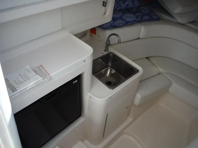Slide: The Image of 1996 Intrepid 339 Walk Around cabin interior with seating and sink. - 36