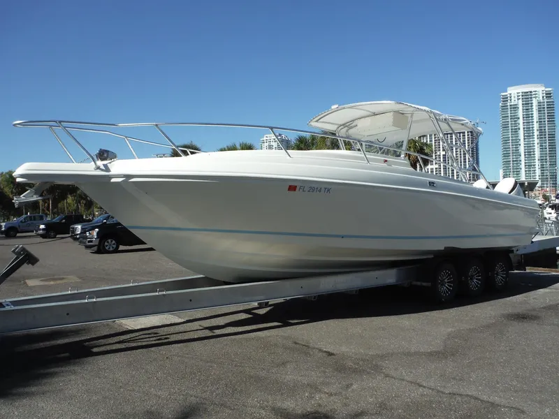 Slide: The Image of 1996 Intrepid 339 Walk Around boat on trailer, featuring dual outboard engines. - 7