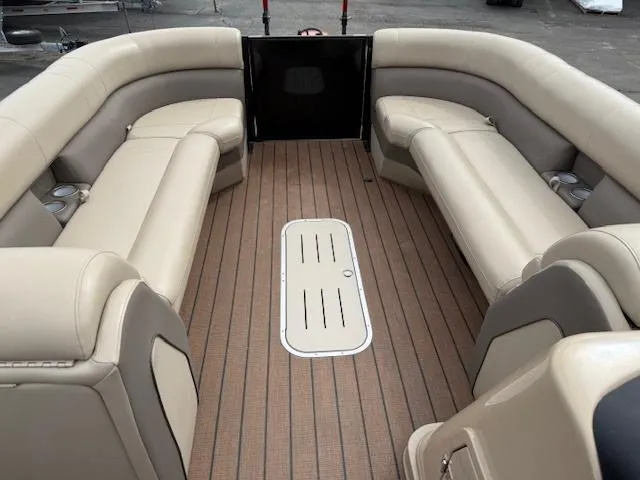 Slide: The Image of 2021 Bentley Pontoons 253 interior with beige seating and wood-style flooring. - 12