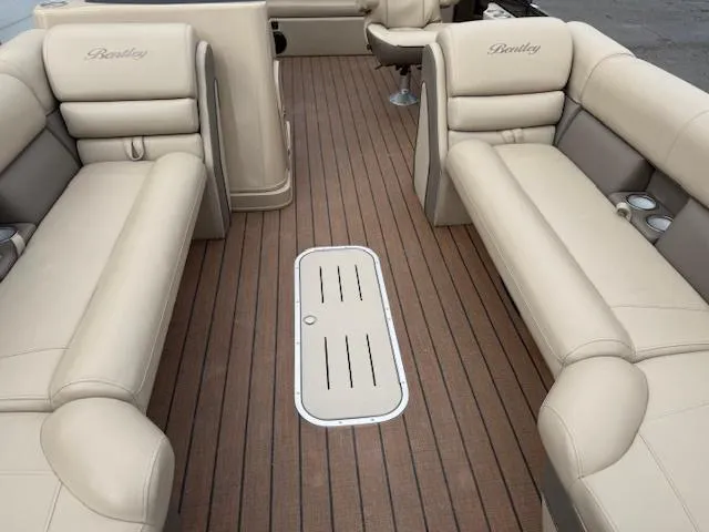 Slide: The Image of 2021 Bentley Pontoons 253 interior with beige seating and wooden deck. - 13