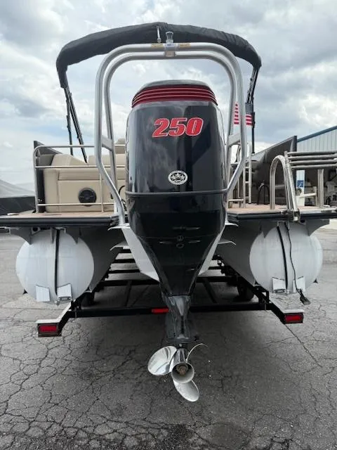 Slide: The Image of 2021 Bentley Pontoons 253 with powerful outboard motor, docked on a trailer. - 16