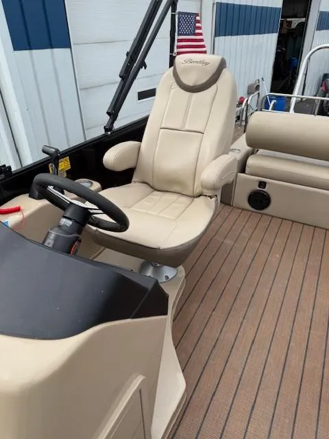 Slide: The Image of 2021 Bentley Pontoons 253 interior with beige captain's chair and steering wheel. - 9