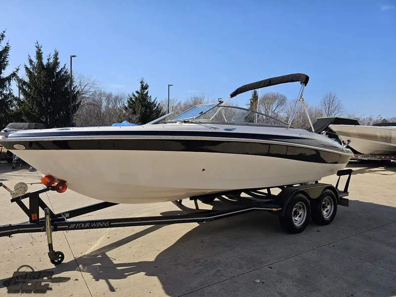 Slide: The Image of 2007 Four Winns 210 Horizon boat on trailer, parked outdoors under clear blue sky. - 13
