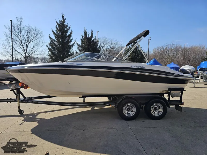 Slide: The Image of 2007 Four Winns 210 Horizon boat on trailer, parked outdoors on a sunny day. - 16