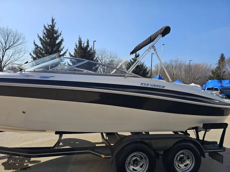 Slide: The Image of 2007 Four Winns 210 Horizon boat on trailer, black and white design, parked outdoors. - 18
