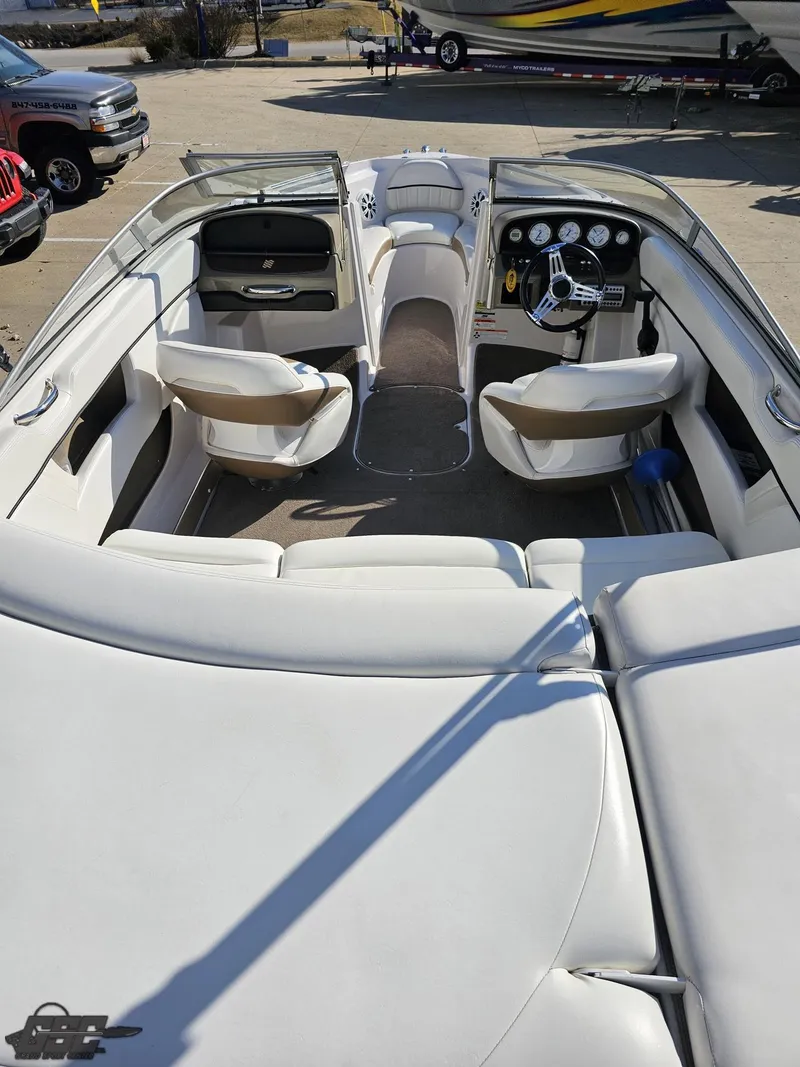 Slide: The Image of 2007 Four Winns 210 Horizon boat interior with white seating and dashboard controls. - 33