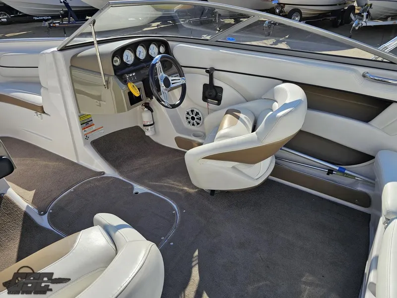 Slide: The Image of Interior of a 2007 Four Winns 210 Horizon boat, featuring steering wheel and seating. - 40