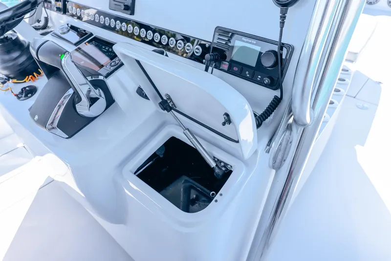 Slide: The Image of 2023 Contender 39ST boat console with open storage compartment and control panel. - 45