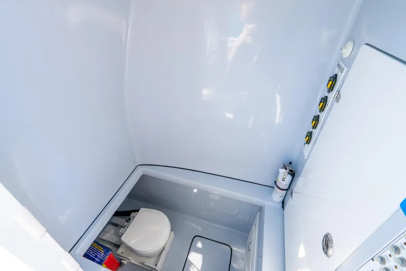 Slide: The Image of 2023 Contender 39ST boat interior with compact marine toilet and control panel. - 46
