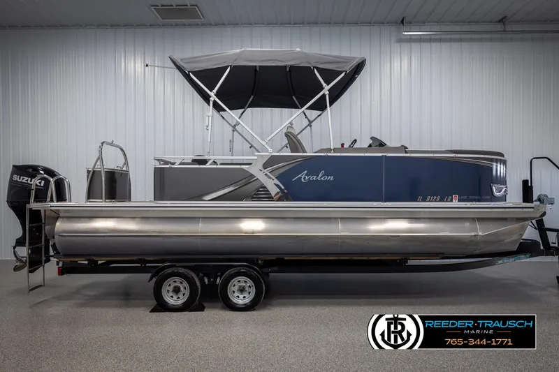 Slide: The Image of 2022 Avalon 2285 LSZ CRB pontoon boat with Suzuki engine, displayed indoors on a trailer. - 5