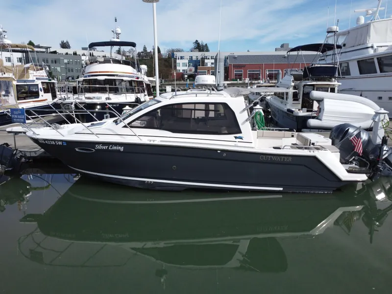 Slide: The Image of 2021 Cutwater C-24 Coupe boat docked in marina, side view. - 2