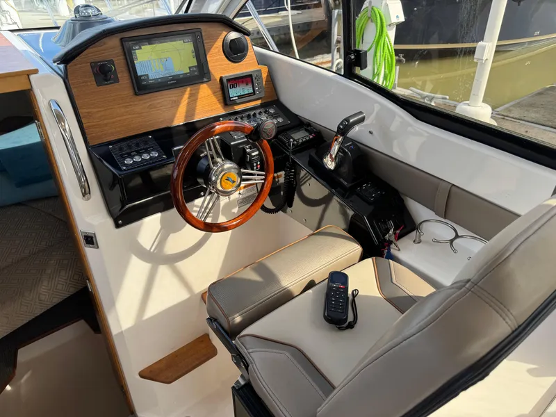 Slide: The Image of 2021 Cutwater C-24 Coupe helm with wood accents, modern controls, and navigation equipment. - 24