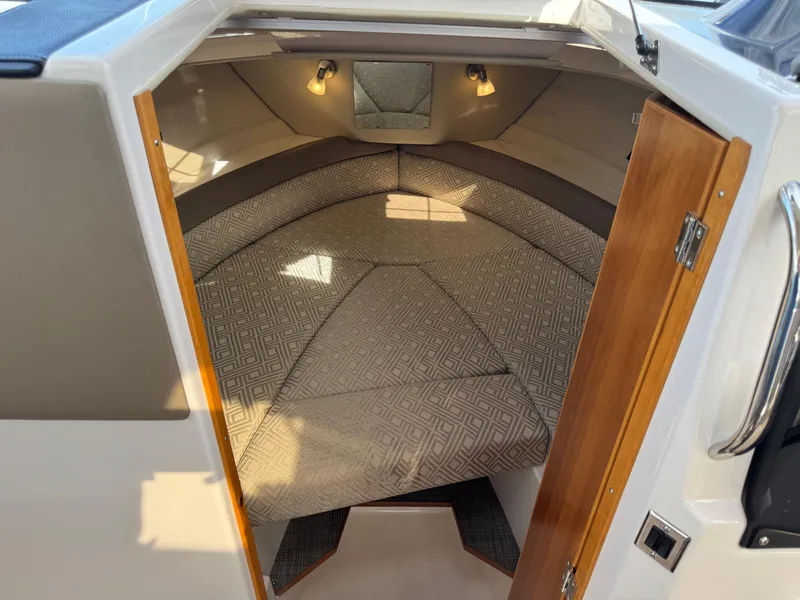Slide: The Image of 2021 Cutwater C-24 Coupe cabin interior with cozy bed and ambient lighting. - 35