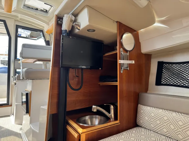 Slide: The Image of 2021 Cutwater C-24 Coupe interior with TV, sink, and seating area. - 36