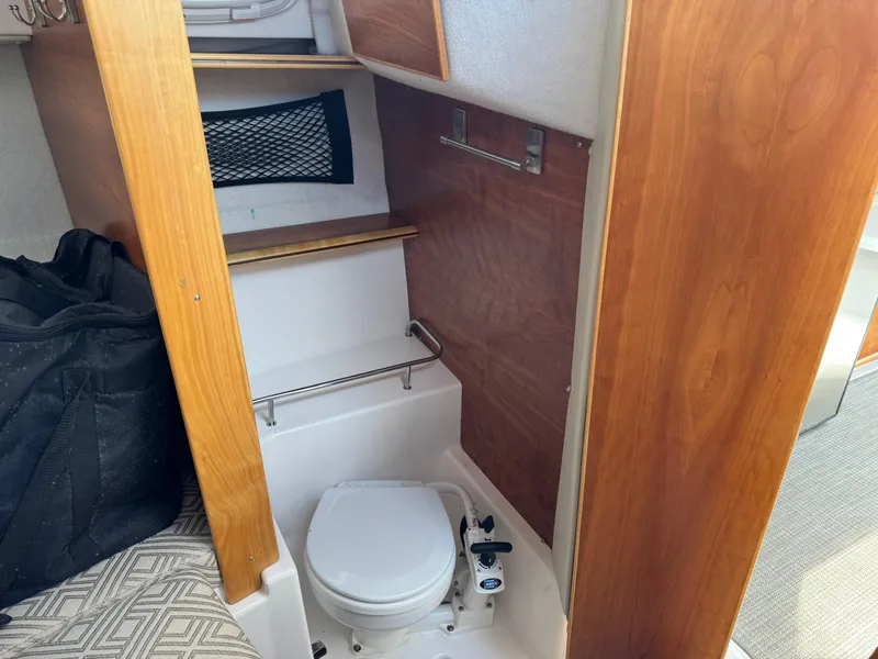 Slide: The Image of 2021 Cutwater C-24 Coupe boat interior with compact bathroom and wooden accents. - 37