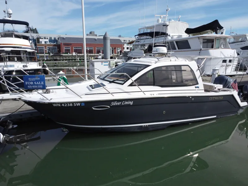 Slide: The Image of 2021 Cutwater C-24 Coupe boat docked at marina, labeled "Silver Lining." - 4