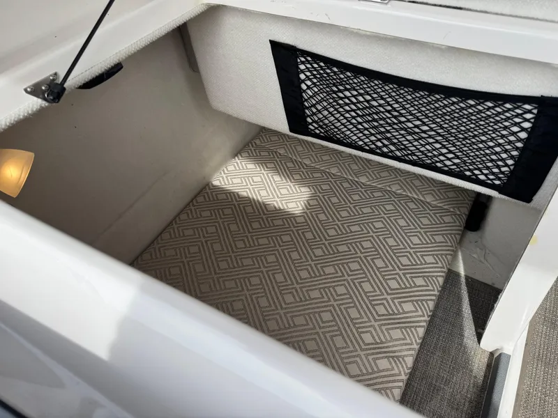 Slide: The Image of 2021 Cutwater C-24 Coupe interior storage compartment with patterned flooring and netted pocket. - 41