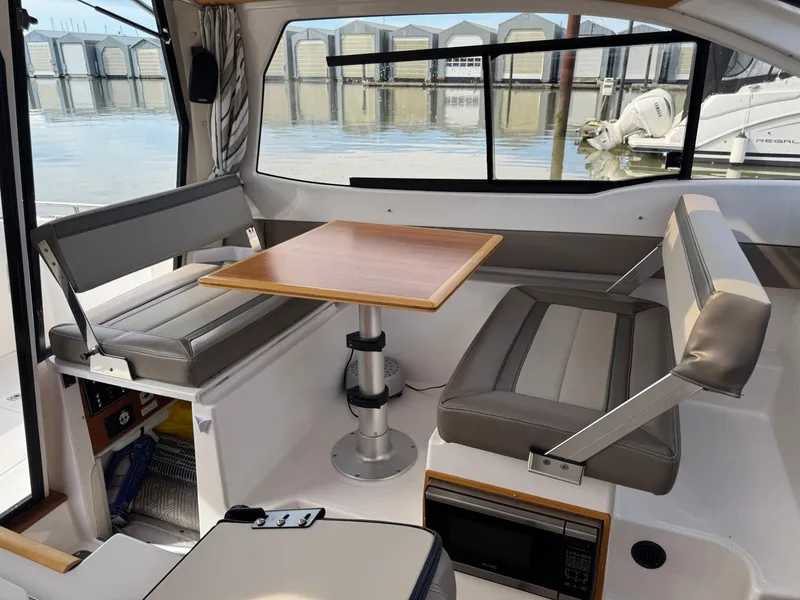 Slide: The Image of Interior of 2021 Cutwater C-24 Coupe with seating and table, docked at marina. - 42