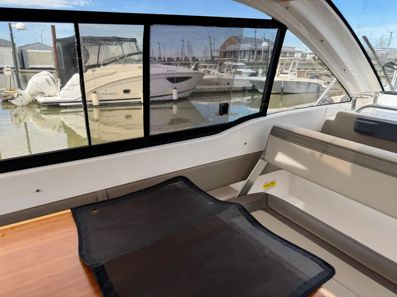 Slide: The Image of Interior view of 2021 Cutwater C-24 Coupe boat with marina in background. - 44