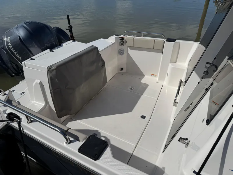 Slide: The Image of 2021 Cutwater C-24 Coupe boat deck with Yamaha engine, docked on calm water. - 8