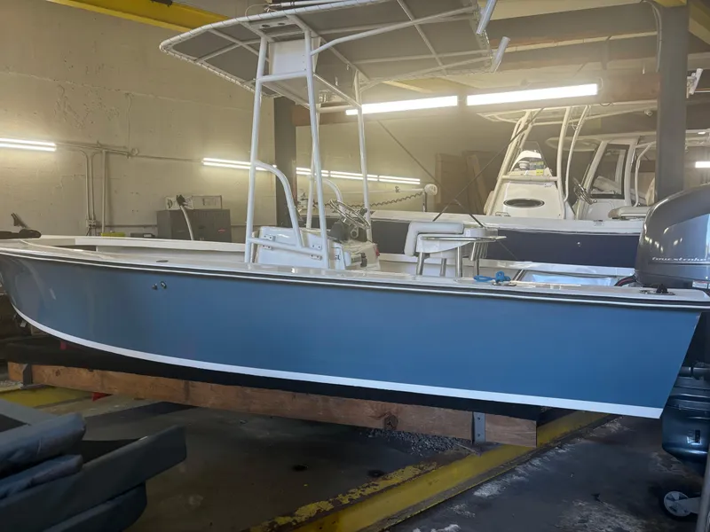 Slide: The Image of 1971 SeaCraft Barcone 21 CC boat in a garage, featuring a blue hull and T-top. - 2